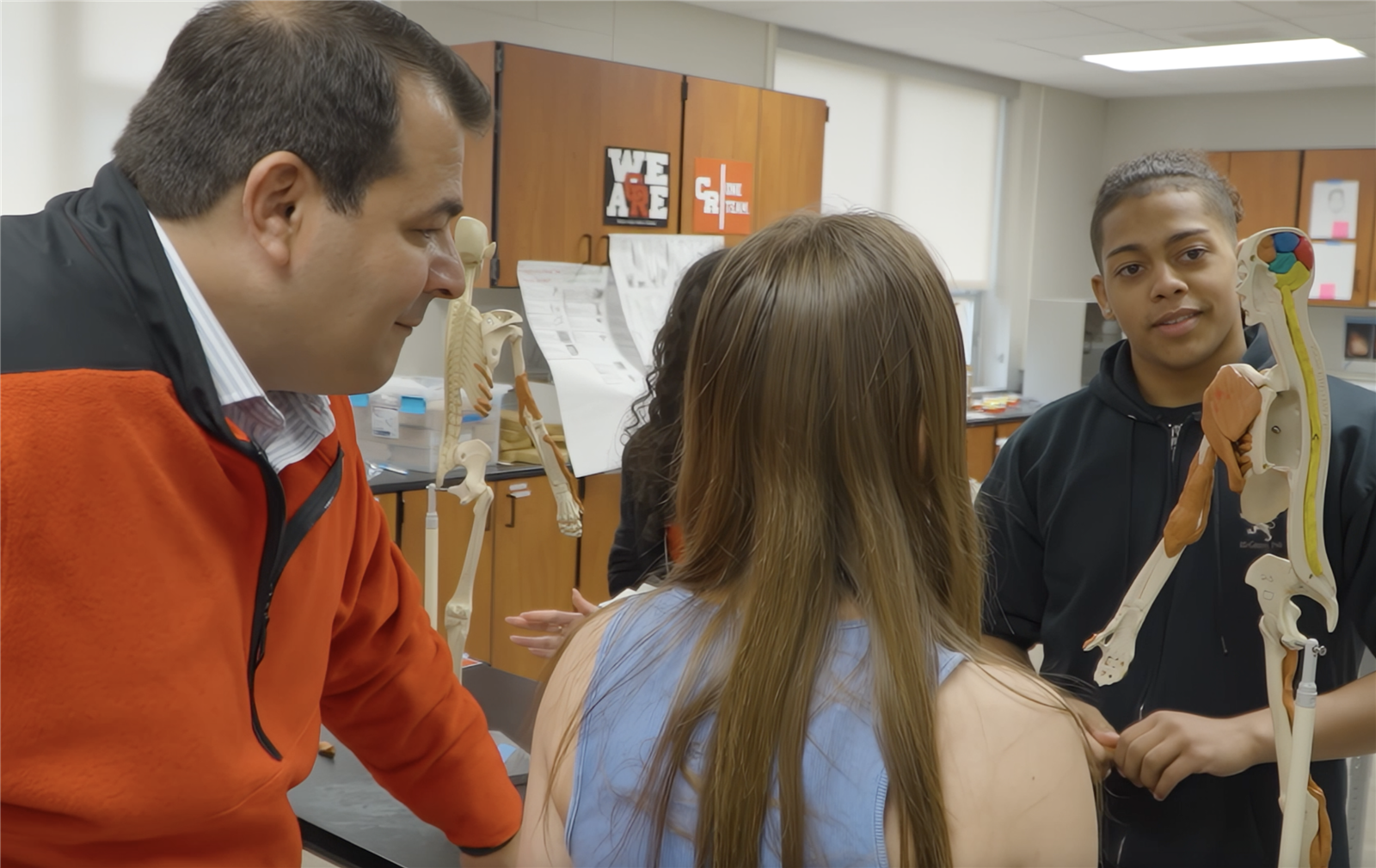 Staff working with students on skeleton